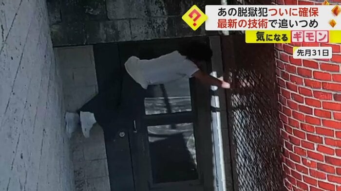 男が両側の壁に手足を伸ばしよじ登っていく