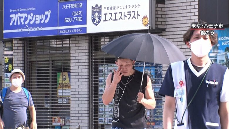 日傘を差す男性の姿も