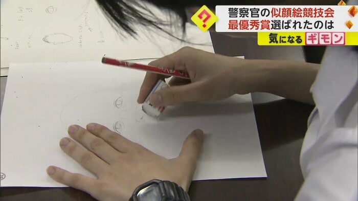 消しゴムを使い、似顔絵を描き直す警察官