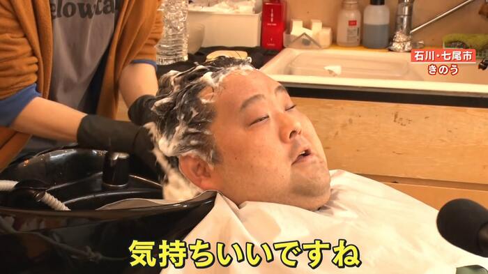 気持ちよさそうにシャンプーをされる客