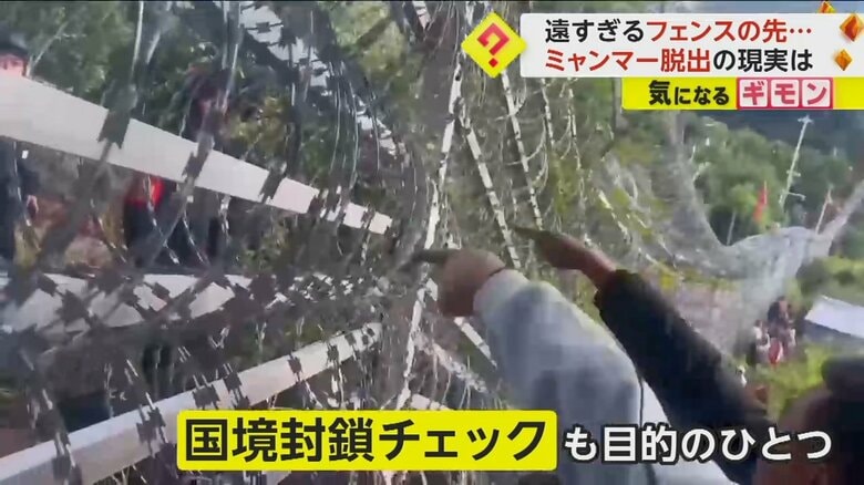 国境にあるフェンス越しにやりとりするミャンマーの人と中国国境警備隊