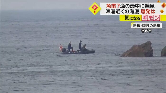 漁港近くの岩場をボートで調べる海上自衛隊