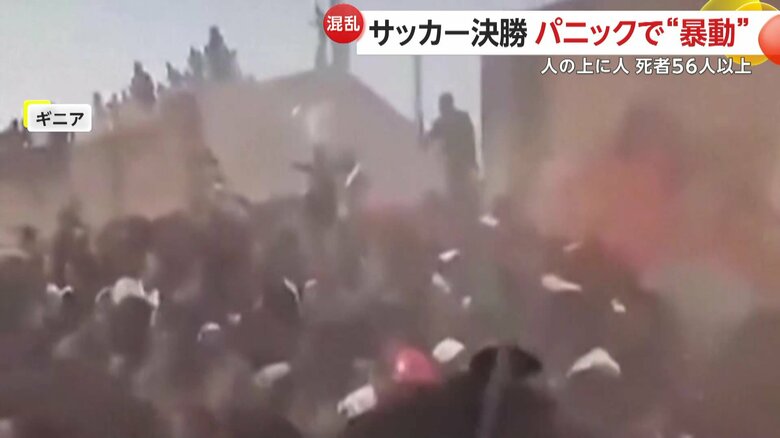 折り重なる群衆の上を歩く人