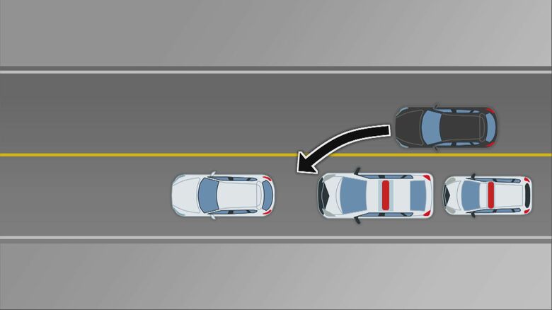 黒い車が白い車とパトカーの間に割み走行を妨害