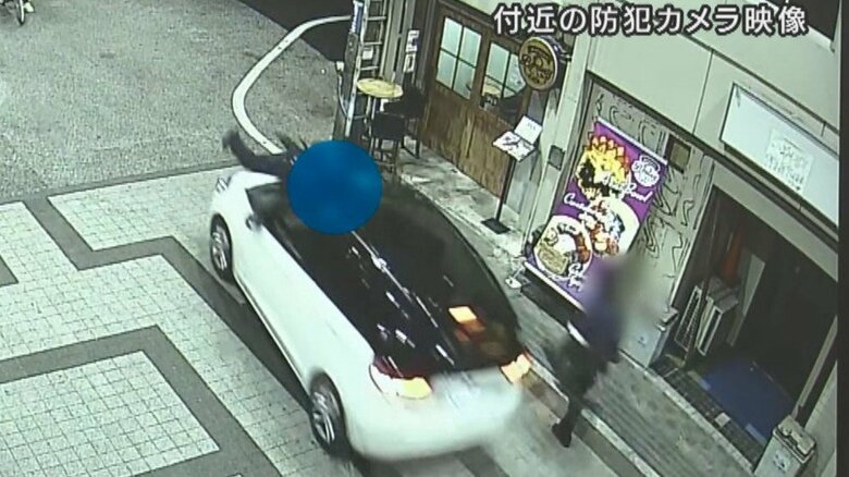 警察官をボンネットに乗せて走る車（付近の防犯カメラより）