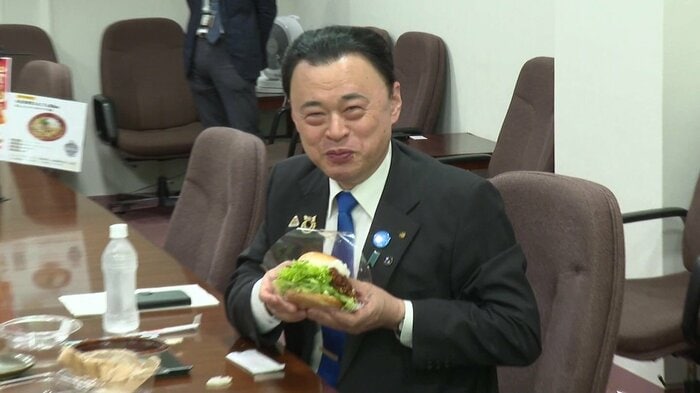 コンテストの受賞商品を手にする丸山知事