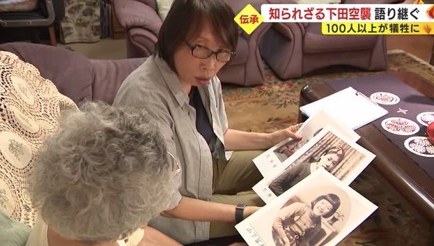 幼き日の育代さんの写真を見る荒井さん母娘
