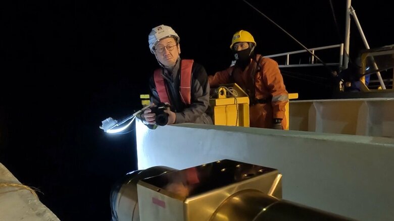 専用の船で海底に設置する様子　左青井氏　提供：防災科学技術研究所