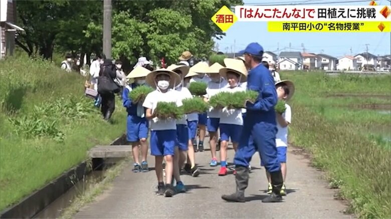 菅笠を身につけ田んぼに向かう