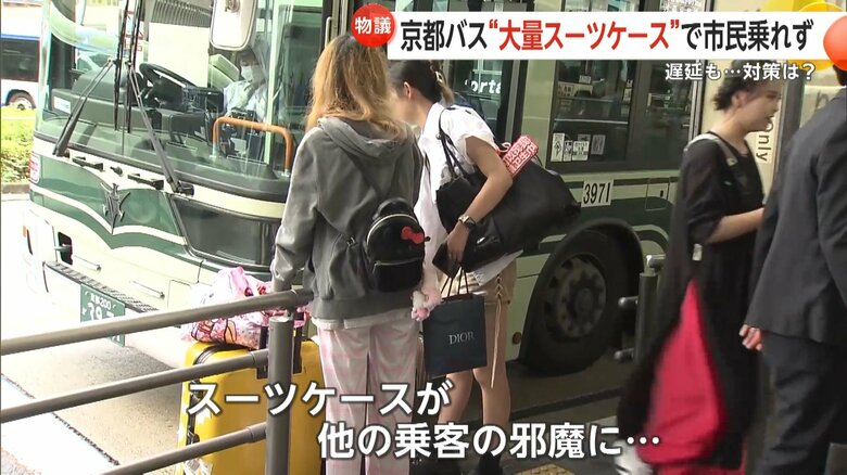 スーツケースがほかの乗客の邪魔になる場面も