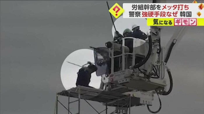 労組の幹部の頭に警察の棒が当たる様子