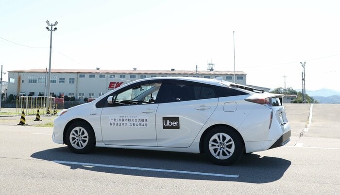 Uberのロゴをつけて走行するライドシェアの車
