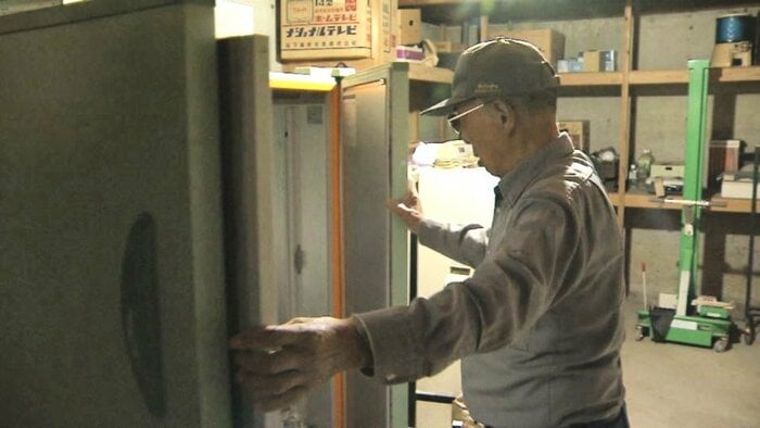 被害のあったコメの貯蔵庫を開ける男性