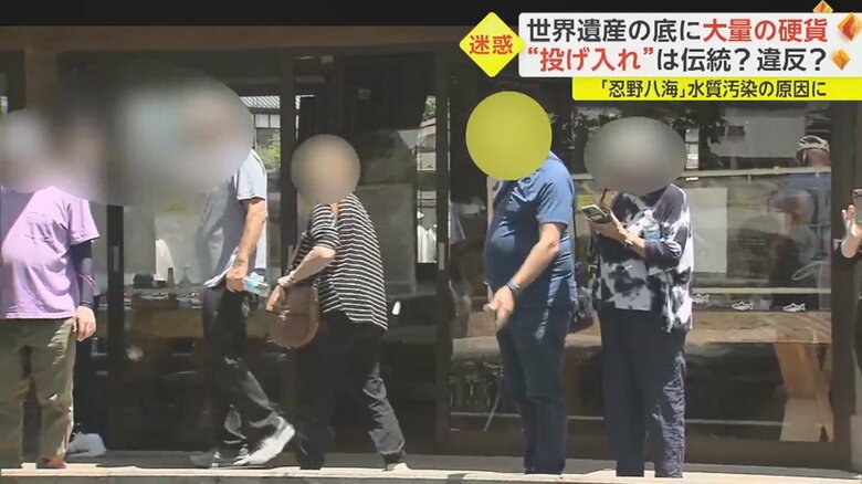 外国人男性が何かを池の中へ…