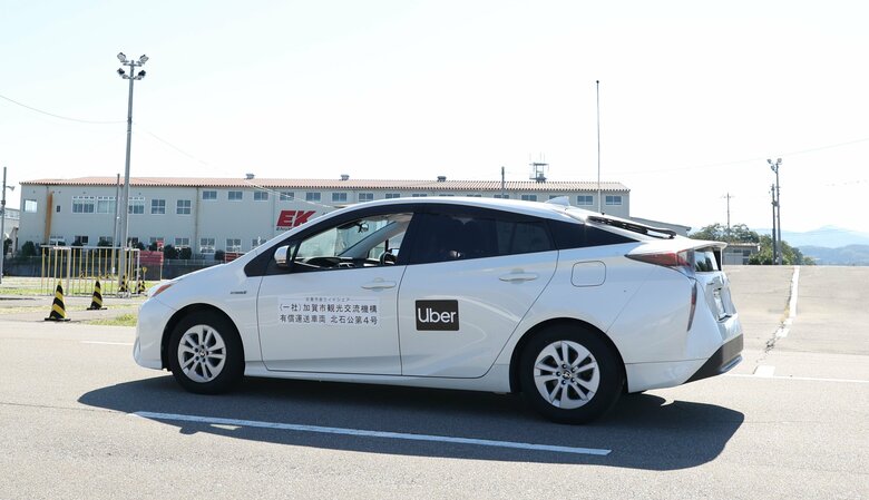 Uberのロゴをつけて走行するライドシェアの車