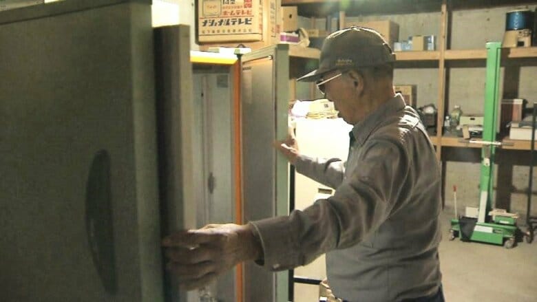 被害のあったコメの貯蔵庫を開ける男性