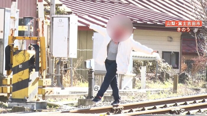 線路の上に立ちポーズを取る