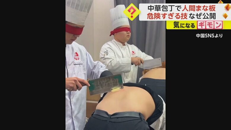 背中の上で食材を切る料理専門学校の生徒