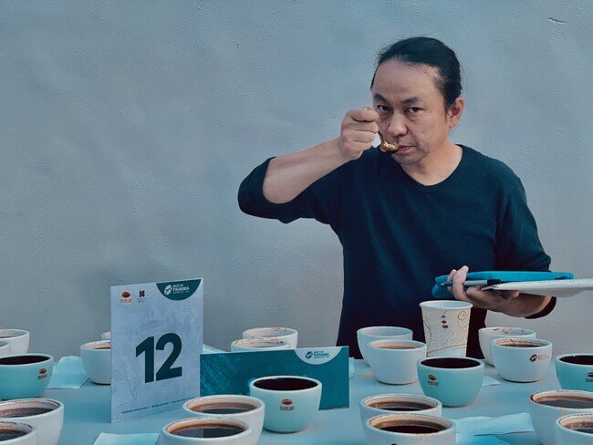 ゲイシャコーヒーを審査するサザコーヒー鈴木太郎 。品評会によって違いはあるが、審査員は同じ条件で抽出されたコーヒーを比べておいしいものを探し、評価シートに味の数値化の作業をする（100点満点）