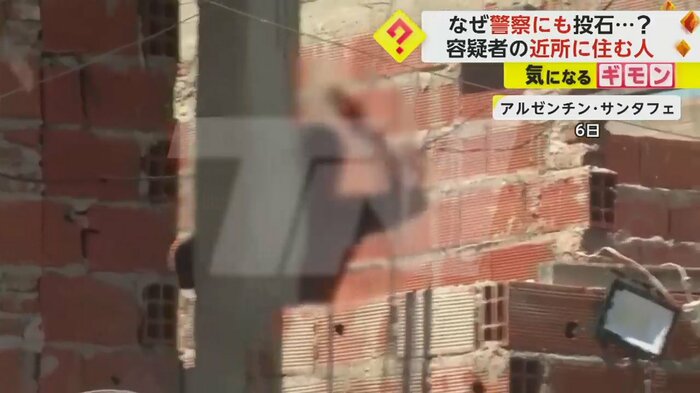 建物の陰で手を挙げる男性