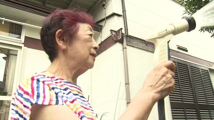 庭の水やりをする西本尚子さん(79)