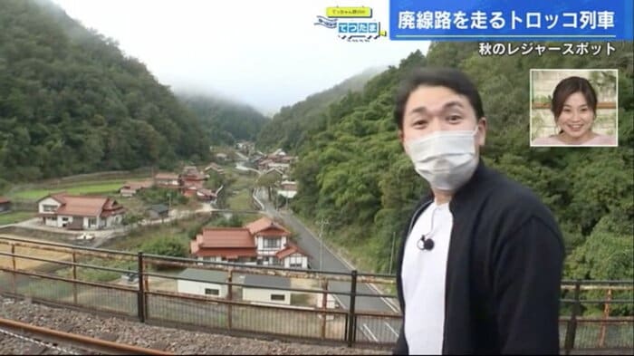 宇都井駅のホームに立ち、満面の笑みを浮かべる野川アナ