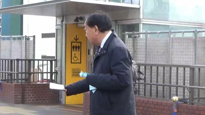 JR津田沼駅前でビラを配る野田前共同代表（2月16日午前）