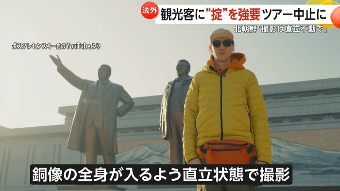 銅像の前で直立状態で撮影するツアーの参加者