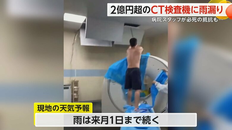 剥がれた天井を押さえようとする上半身裸になった男性スタッフ