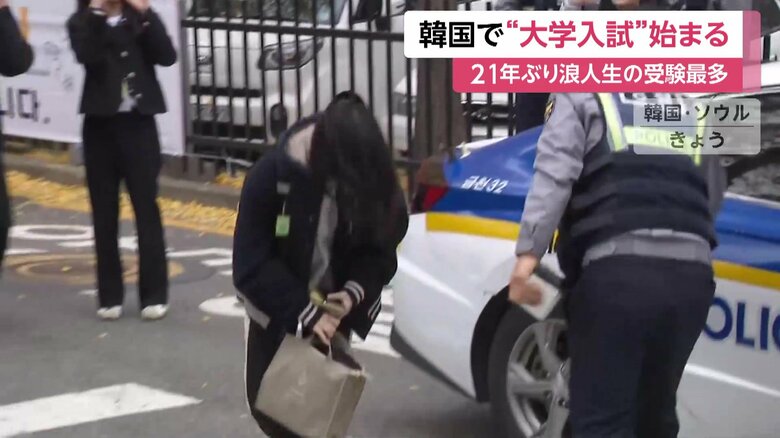 パトカーで会場入りする受験生