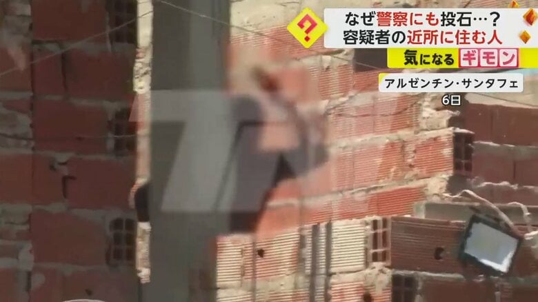 建物の陰で手を挙げる男性