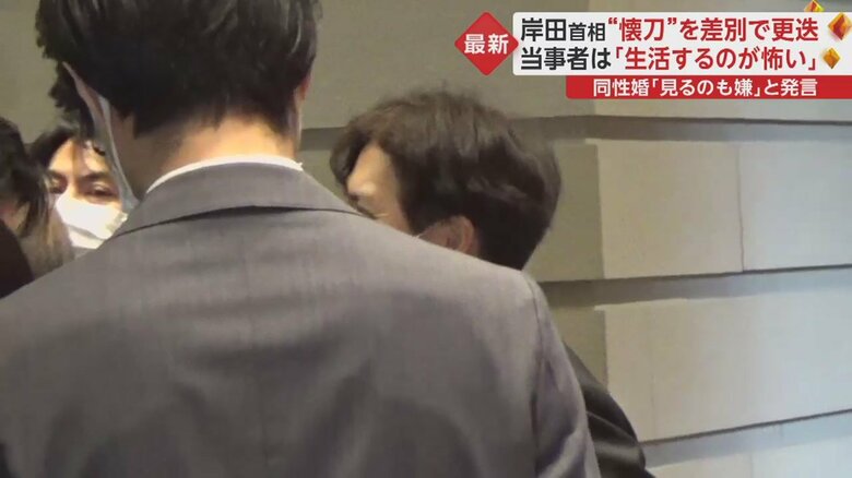 さりげなく記者の陰に（画像：「イット！」2月6日放送より）