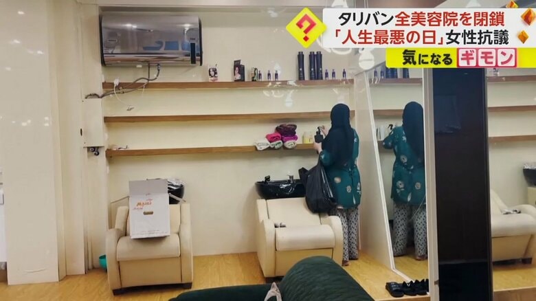 棚に並べてある商品を回収する女性