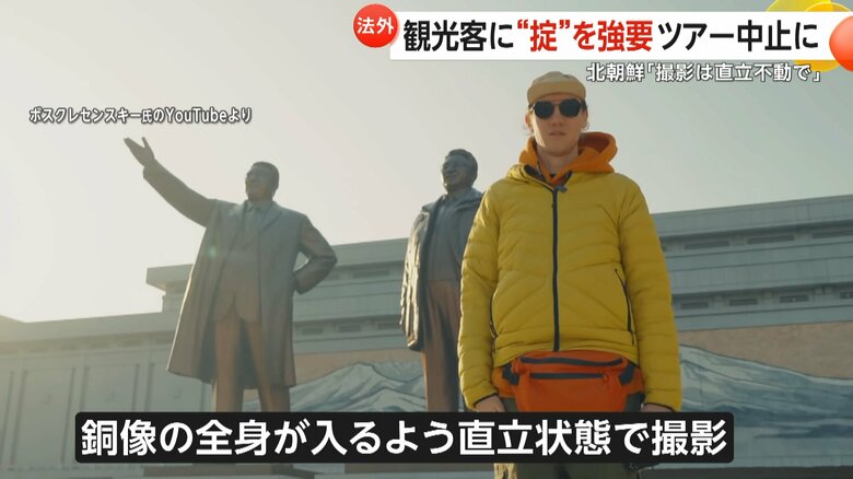 銅像の前で直立状態で撮影するツアーの参加者