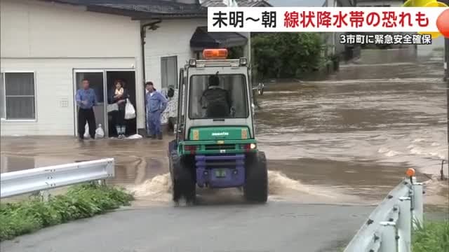 浸水した事業所前で迎えを待つ人たち(五城目町)