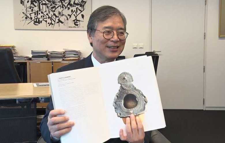 縄文展の目録を手に記録係を務めた当時を語るパリ日本文化会館・杉浦勉館長