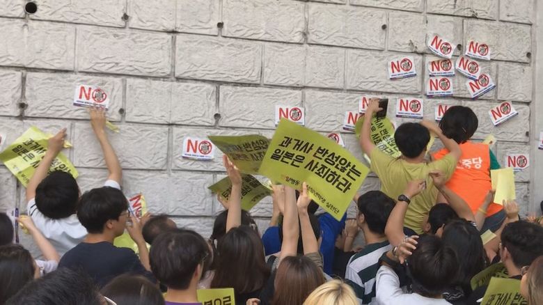 日本総領事館前での抗議集会 参加者が壁に抗議メッセージを貼り付けているが警察官は野放しだ
