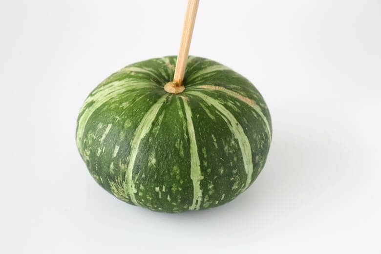 硬いかぼちゃを切るときは、まずお尻の花落ちに菜箸を深く差し込みます