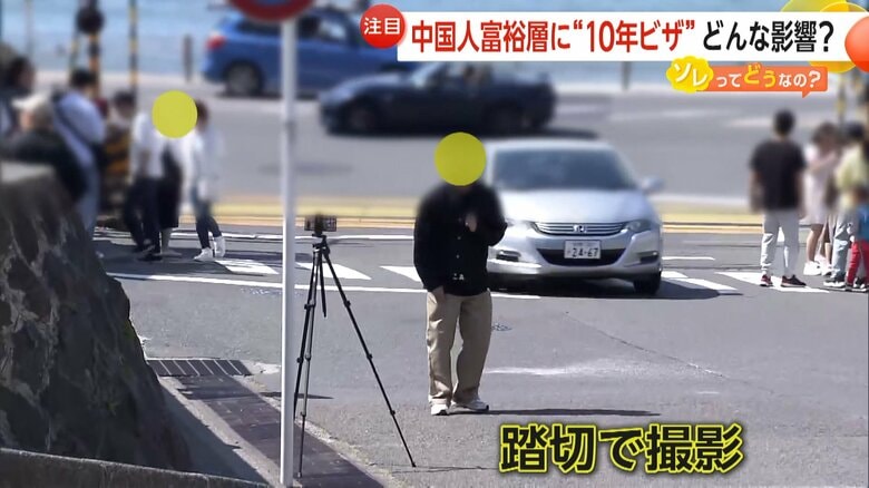 人気漫画の舞台になった踏切で撮影する外国人観光客