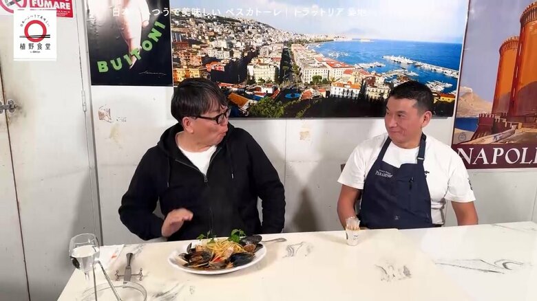 「ペスカトーレ」を食べあまりの美味しさに膝を叩く植野さんとオーナーシェフ・久野さん