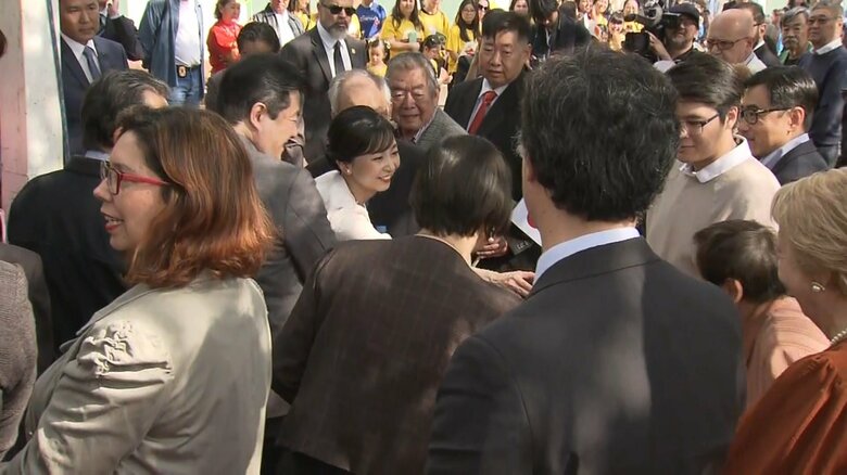 集まった人と手を伸ばし合って握手される佳子さま