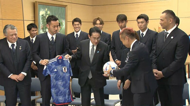 岸田首相に、吉田選手は日本代表のユニフォームを、長友選手はサッカーボールを手渡した。