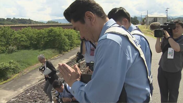 事故現場で手を合わせる警察官
