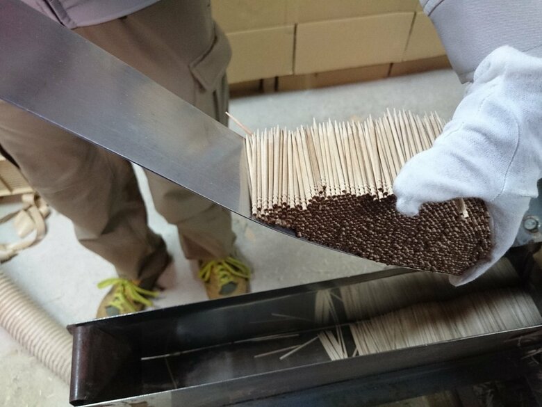 機械からつまようじを出しているところ　これをケースにつめていく