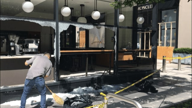 暴動で窓ガラスを割られた店舗 防護のため街中のガラスが板で覆われている