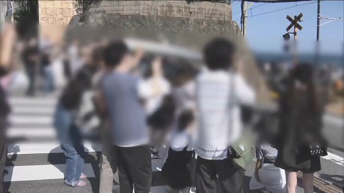 神奈川・鎌倉市の踏切に集まる多くの観光客