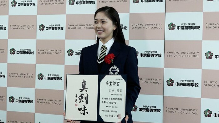 卒業証書を手にして笑顔を見せる吉田