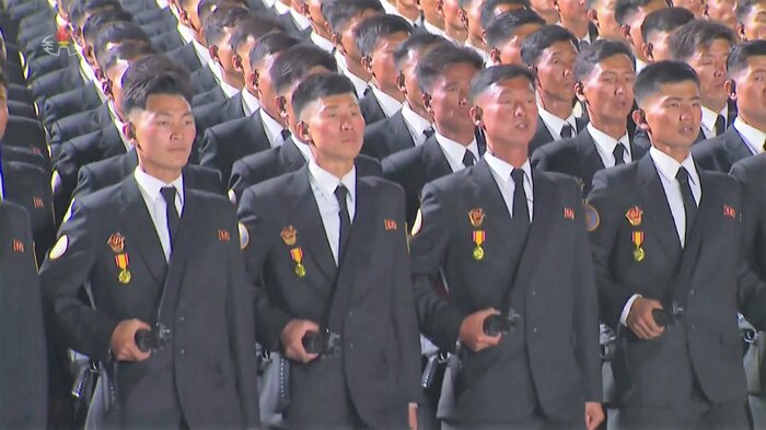 背広姿で銃器を持ってパレードに参加する国家保衛省と見られる部隊(朝鮮労働新聞・2022年4月26日)