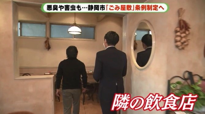 隣の飲食店 窓側が物があふれた家と接している