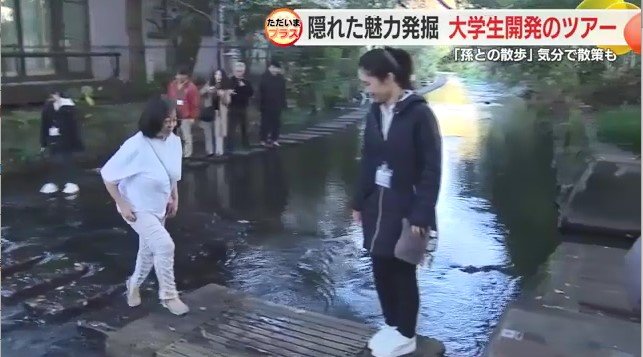 水辺を散策中の参加者と学生